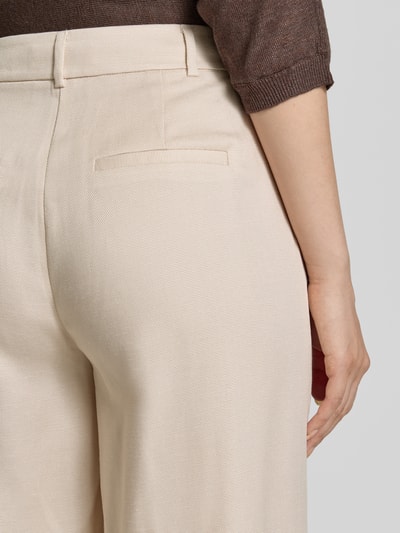 Kobiece modelka ma na sobie spodnie materiałowe 'Stoffhose mit Gesäßleistentaschen' od comma z mieszanki lyocellu i bawełny, kieszenie tylne z wypustką, beżowy, długość wewnętrzna nogawki 78 cm, szerokość w rozmiarze 36/32: 39 cm, detal z bliska tylnej części