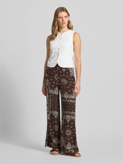 Frauenmodel trägt Relaxed Fit Weite Hose aus reiner Viskose Modell 'KAVI' von Only, braun mit Muster, Ganzkörperansicht von vorne. Damen Weite Hose.