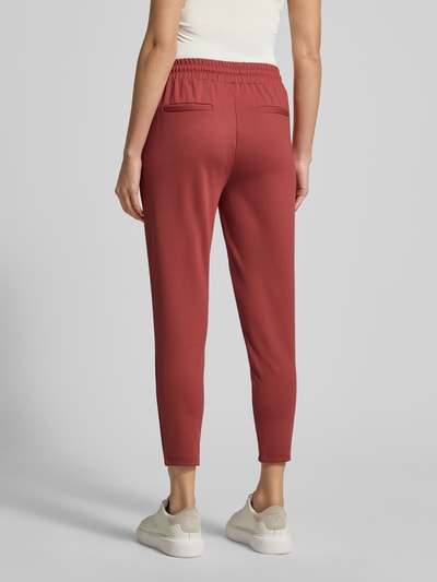 Frauenmodel trägt Stoffhose mit elastischem Bund Modell 'KATE' von ICHI in Rot, Material-Mix, gerader Schnitt, Ganzkörperansicht Rückansicht.