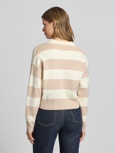 Frauenmodel trägt Strickpullover mit Polokragen von Guess Jeans, Viskose-Mix, Lockerer-Schnitt, creme-beige gestreift, Rückenlänge 48 cm, Ganzkörperansicht Rückansicht.