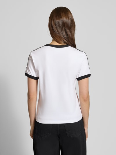 Frauenmodel trägt Slim Fit T-Shirt aus Baumwoll-Mix von adidas Originals, weiß mit schwarzen Details, kurzärmelig, Ganzkörperansicht Rückansicht.
