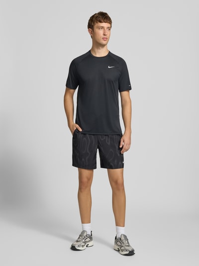 Männermodel trägt schwarze Regular Fit Sportshorts mit Dri-FIT-Technologie von Nike Training, dezente Musterung, Ganzkörperansicht von vorne.