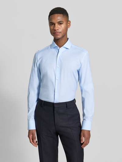 Männermodel trägt Slim Fit Freizeithemd aus reiner Baumwolle von BOSS in Hellblau, Popeline, Haifischkragen, unifarben, Ganzkörperansicht von vorne.
