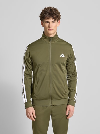 Männermodel trägt Regular Fit Sweat-Anzug mit Kontraststreifen von adidas Sportswear, Optik: Unifarben, Ganzkörperansicht von vorne.