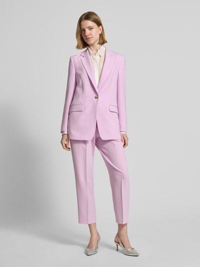 Frauenmodel trägt Regular Fit Longblazer mit Reverskragen Modell 'JOCALUAH' von BOSS in zartem Rosa mit Pattentaschen, Twill-Materialverarbeitung, Ganzkörperansicht von vorne.