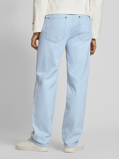 Männermodel trägt Loose Fit Jeans mit Kontrastnähten von KARL KANI in Hellblau, 5-Pocket-Design, Rückansicht, Ganzkörperansicht.