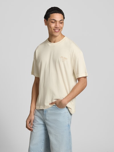 Männermodel trägt T-Shirt mit Rundhalsausschnitt von Jack & Jones in Beige mit Print aus Reine Baumwolle, Regular-Fit, Nahaufnahme Oberkörper.
