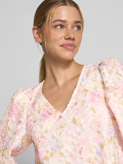 Frauenmodel trägt Cocktailkleid mit V-Ausschnitt Modell 'LEANNA' von YAS, florales Muster in Rosa und Beige, 3/4-Arm, Nahaufnahme Oberkörper. Damen Cocktailkleid in A-Linie, Minikleid, Rückenlänge bei Größe 36: 87 cm, Brustweite: 46 cm, Ärmellänge: 48 cm.