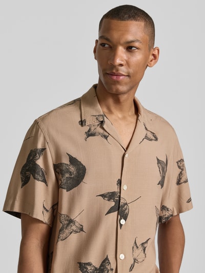 Männermodel trägt Regular Fit Freizeithemd aus reiner Viskose Modell 'TERRY' von SELECTED HOMME, beige mit Blattmuster, Nahaufnahme Oberkörper, Herren Freizeithemd von SELECTED HOMME.