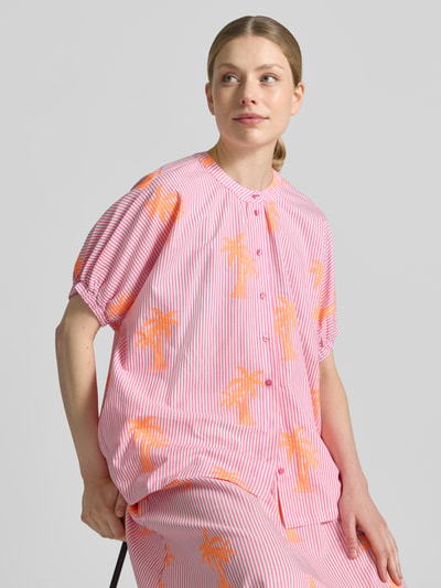 Frauenmodel trägt Bluse mit Rundhalsausschnitt und Knopfleiste von Milano Italy, Baumwoll-Mix mit Stretch-Anteil, rosa-weiß gestreift mit orangen Palmenmotiven, Straight Fit, elastische Ärmelabschlüsse, Rückenlänge 63 cm bei Größe 36, Nahaufnahme Oberkörper.