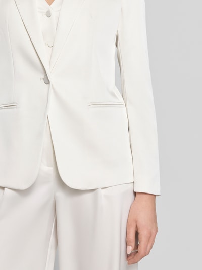 Frauenmodel trägt Slim Fit Blazer mit Paspeltaschen von Jake*s Cocktail in Weiß, Satin, mit Reverskragen und Knopfverschluss, Nahaufnahme Oberkörper.