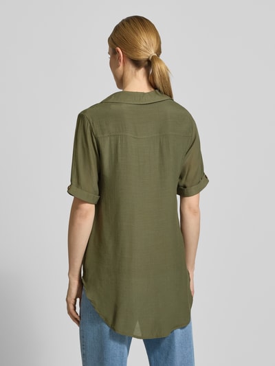 Frauenmodel trägt Relaxed Fit Bluse aus Viskose-Mix mit Umlegekragen von Apricot, semitransparentes Design, Rückseite verlängert, Halbarm, Knopfleiste, grün, Struktur fein, Ganzkörperansicht Rückansicht.