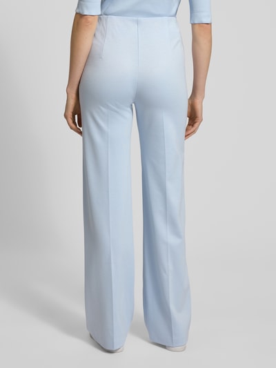 Frauenmodel trägt Stoffhose aus Viskose-Mix mit Bügelfalten von Marc Cain in Hellblau mit Regular-Fit, elastischer Bund, Reißverschlusstaschen, Label-Detail, Ganzkörperansicht Rückansicht, Bundweite 37 cm, Innenbeinlänge 80 cm bei Größe 36.
