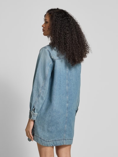 Modelka nosi Jeanskleid mit Knopfleiste Modell 'TONA' od Bash z bawełny, prosty krój, sukienka mini, kołnierzyk koszulowy, listwa guzikowa, długość tyłu w rozmiarze S: 84 cm, szerokość w rozmiarze S: 53 cm, długość rękawów w rozmiarze S: 58 cm. Całkowity widok z tyłu.
