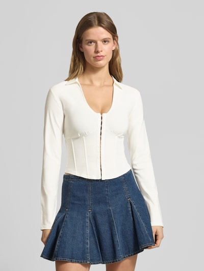 Frauenmodel trägt Slim Fit Bluse aus Viskose-Mix in Korsett-Optik von Gina Tricot, V-Ausschnitt, Hakenverschluss, Langarm, Creme, Ganzkörperansicht von vorne.