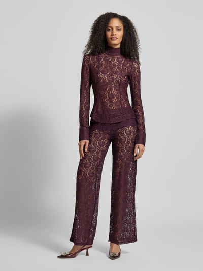 Frauenmodel trägt Blusenshirt mit Stehkragen Modell 'GRACE' von Mango, semitransparent, lila, florale Spitze, Slim Fit, Ganzkörperansicht von vorne.