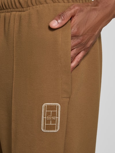 Männermodel trägt Loose fit Sweathose aus katoenmix model 'Tenn' van Lacoste, bruin met geborduurd logo, detailopname, Heren Sweathose von Lacoste