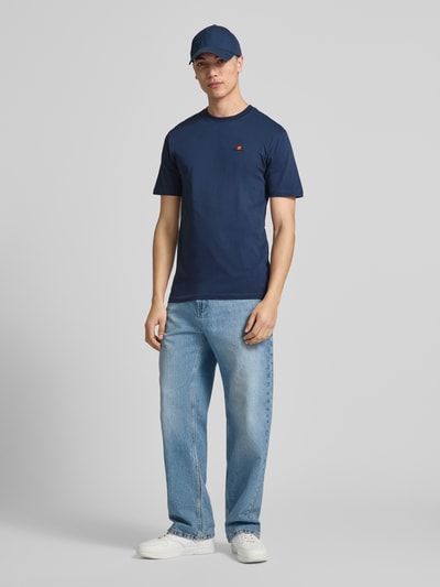 Męski model nosi T-Shirt mit Label-Stitching Modell 'CASSICA' od Ellesse, bawełna, krój regular fit, granatowy, widok całej sylwetki z przodu.