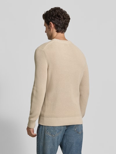 Männermodel trägt Regular Fit Strickpullover aus reiner Baumwolle von MCNEAL, beige Farbe, grobe Strickstruktur, Rückenansicht, Ganzkörperansicht Rückansicht. Rückenlänge 73 cm, Ärmellänge 53 cm, Rundhalsausschnitt, elastische Abschlüsse.