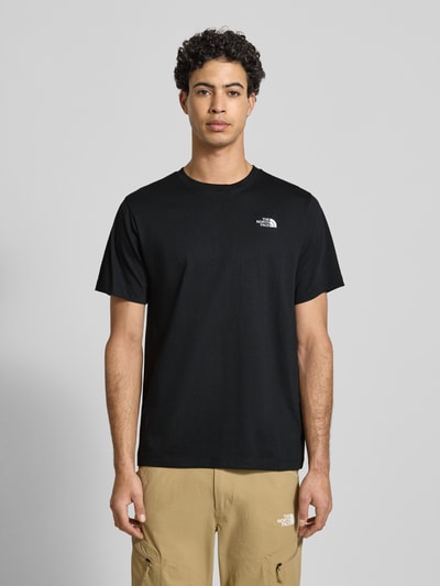 Mężczyznamodel nosi Regular Fit T-Shirt mit Logo-Stitching von The North Face, czarny bawełniany mix, krój regular fit, okrągły dekolt, długość tyłu w rozmiarze M: 70 cm, gładka struktura, przód na całej sylwetce