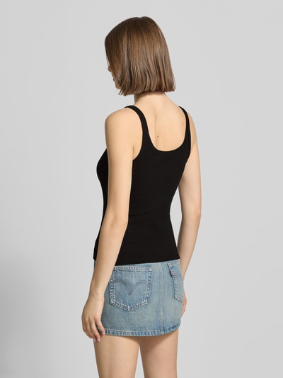 Frauenmodel trägt schwarzes Tanktop in Ripp-Optik Modell 'MOLLY' von Topshop aus Baumwoll-Elasthan-Mix, Slim-Fit, Rückenlänge 38 cm, Ganzkörperansicht Rückansicht.