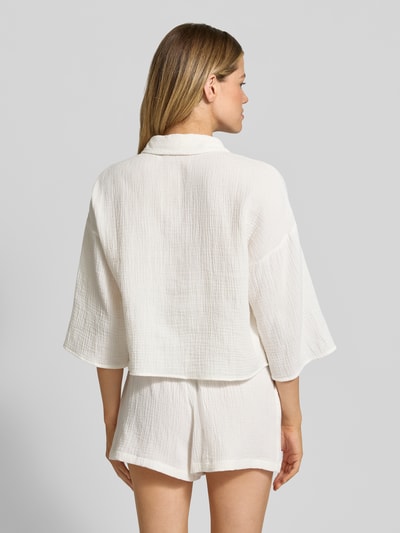 Frauenmodel trägt Loose Fit Hemdbluse aus reiner Baumwolle Modell 'NATALI' von Vero Moda, weiß, Seersucker, Ganzkörperansicht Rückansicht.