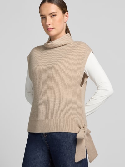 Kobiece model prezentuje Relaxed Fit Pullunder aus reinem Kaschmir mit Stehkragen von Christian Berg Woman, beżowy, Ozdobna kokarda na dole, stójka, bez rękawów, długa tekstura, długość tyłu w rozmiarze S 52 cm, Ganzkörperansicht von vorne.