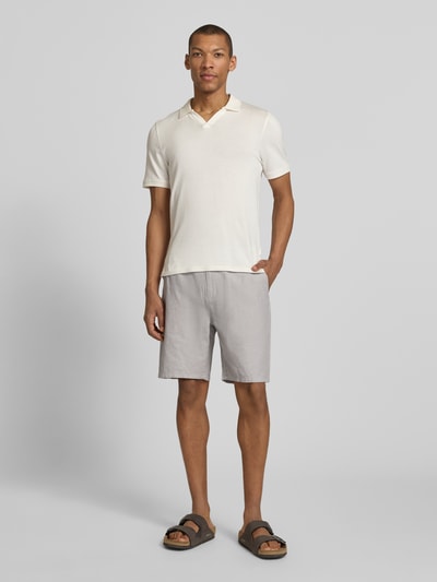 Männermodel trägt Shorts mit elastischem Bund von Scotch & Soda aus Baumwoll-Leinen-Mix, Regular Fit, hellgrau, Ganzkörperansicht von vorne.