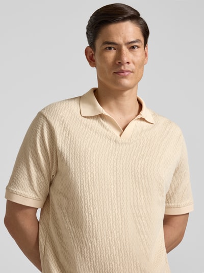 Männermodel trägt Regular Fit Poloshirt mit V-Ausschnitt Modell 'ACAYO' von Drykorn, beigefarbener Baumwoll-Mix, Nahaufnahme Oberkörper.