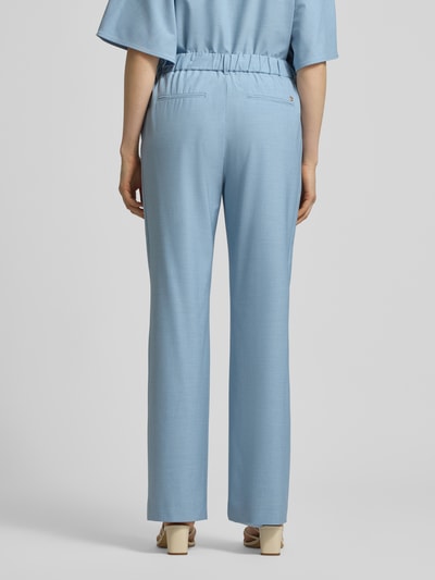 Vrouwenmodel draagt broek van viscosemix model 'Bai Roy' van MOS MOSH in lichtblauw met elastische band en achterzakken, slim fit, modelinformatie, volledig lichaam achteraanzicht.