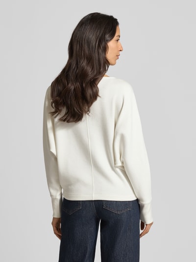 Vrouwenmodel draagt gebreide pullover met boothals Model 'UTIBBY' van Someday, materiaalmix met viscose, los model, ribboorden, ruglengte 54 cm, mouwlengte 60 cm, kleur crèmewit, rechte vormen en zachte textuur. Ganzkörperansicht Rückansicht.