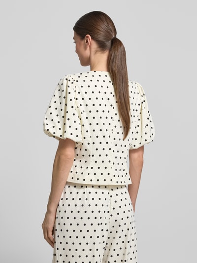 Frauenmodel trägt Slim Fit Bluse mit Puffärmeln Modell 'ANELA DOT' von Neo Noir im Schwarz-Weiß-Punktmuster, Material-Mix mit Stretch-Anteil, Rückenlänge 45 cm, Ärmellänge 28 cm, Ganzkörperansicht Rückansicht.