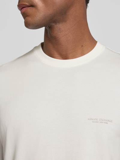 Männermodel trägt Extra Slim Fit T-Shirt mit Rundhalsausschnitt von Armani Exchange, Logo, weiße glatte Textur, Nahaufnahme Oberkörper, Rückenlänge bei Größe M 70 cm.