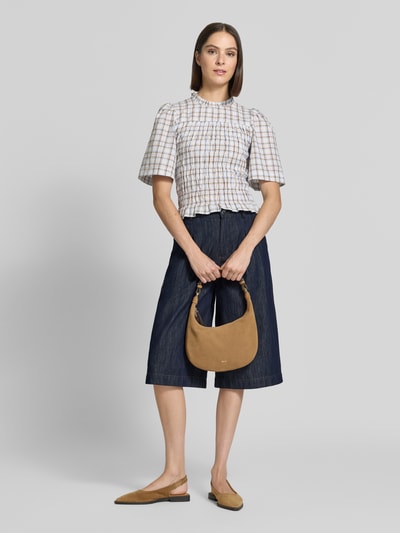 Frauenmodel trägt Wide Fit Jorts aus reiner Baumwolle von Oiu, Jeansblau, Bundfalten, Knopf- und Reißverschluss, Ganzkörperansicht von vorne.