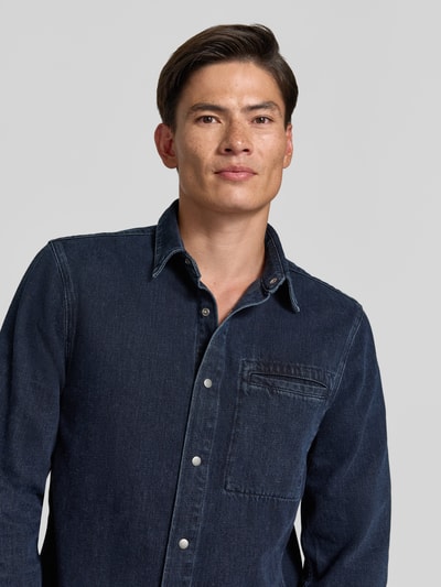 Männermodel trägt dunkelblaues Regular Fit Freizeithemd aus reiner Baumwolle Modell 'WELT' von ARMEDANGELS, Nahaufnahme Oberkörper, Herren Freizeithemd.