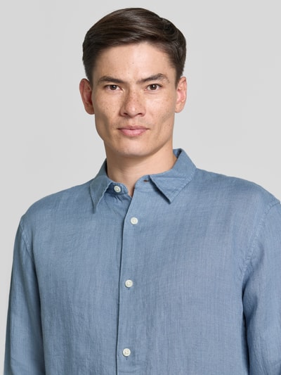 Männermodel trägt Regular Fit Leinenhemd mit Kentkragen von GAP, reine Leinen, hellblau, Knopfleiste, Nahaufnahme Oberkörper.