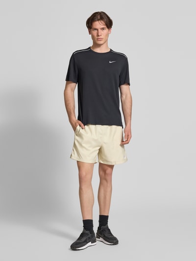 Männermodel trägt Shorts mit Label-Stitching und elastischem Bund von Nike in Beige, Regular-Fit, Tunnelzug, Ganzkörperansicht von vorne. Bundweite bei Größe M: 41 cm, Innenbeinlänge bei Größe M: 14 cm.
