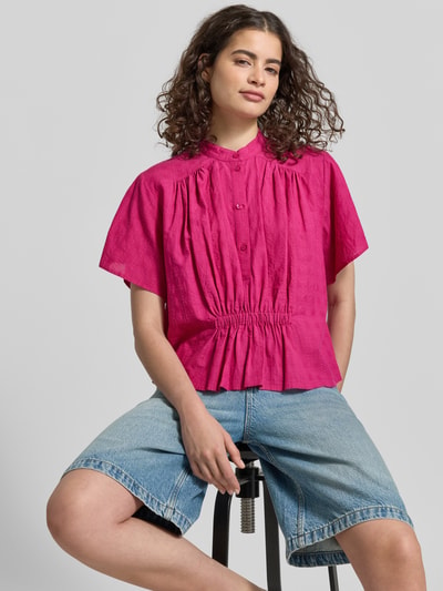 Kobiece modelka nosi Boxy Fit Bluse mit Stehkragen und Knopfleiste von Jake*s Casual z bawełny, pudełkowy krój, stójka, listwa guzikowa, długość tyłu w rozmiarze 38: 54 cm, długość rękawów w rozmiarze 38: 21 cm, intensywny róż, prosta faktura, szerokie rękawy, całkowity widok z przodu, zbliżenie górnej części ciała.