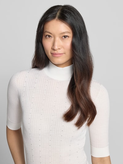 Frauenmodel trägt Slim Fit Longsleeve aus reiner Lanawolle Modell 'Maglia Costine' von Liu Jo White, semitransparent, weiß, Nahaufnahme Oberkörper.