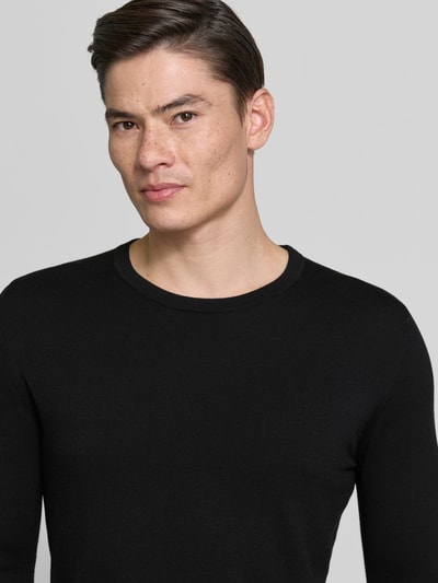 Männermodel trägt Slim Fit Pullover in Strick-Optik Modell 'Mino' von Drykorn, Reine Baumwolle, Rundhalsausschnitt, Nahaufnahme Oberkörper.