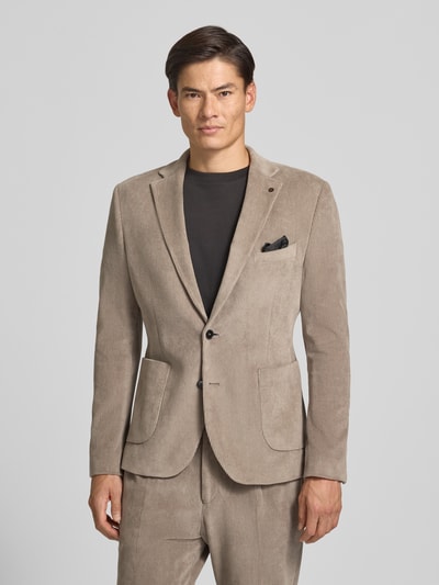 Männermodel trägt Slim Fit Sakko aus Baumwoll-Mix in Cord-Optik Modell 'Nick' von Zuitable in Beige mit Reverskragen, Ganzkörperansicht von vorne. Elastischer Stoff, aufgesetzte Taschen, 2-Knopfleiste, Brusttasche, moderne Textur.