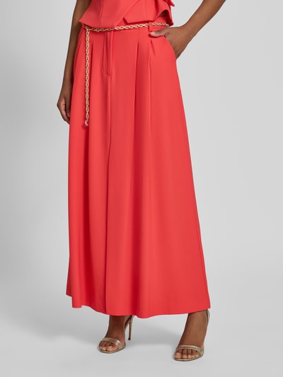 Frauenmodel trägt Midirock mit Drapierungen und Gürtel von Rinascimento in leuchtendem Rot, A-Linie, glatte Stofftextur, Nahaufnahme Oberkörper. Material-Mix mit Stretch-Anteil ist erkennbar, Bundweite und Innenbeinlänge laut Größe S passend.