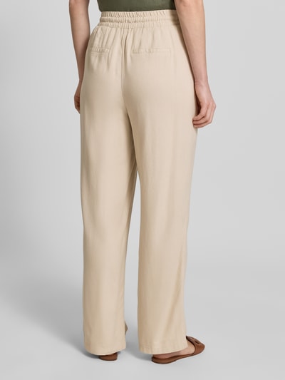 Frauenmodel trägt Loose Fit Weite Hose aus Viskose-Leinen-Mix Modell 'JESMILO' von Vero Moda, einfarbig, elastischer Bund, Ganzkörperansicht Rückansicht.