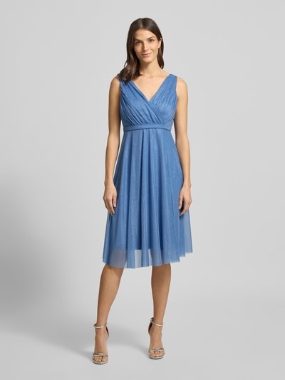 Frauenmodel trägt Regular Fit Kleid mit Glitzer-Mesh von TROYDEN COLLECTION in Blau, taillierte Passform, Knielänge, V-Ausschnitt, ärmelloses Design, feine Glitzer-Textur, Ganzkörperansicht von vorne.
