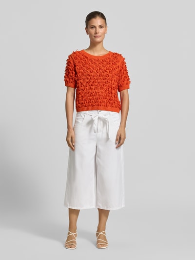 Frauenmodel trägt Strickpullover mit Rundhalsausschnitt und 1/2-Arm von Oui in Orange, strukturierte Oberfläche, Reine Baumwolle, Gerader-Schnitt, Gerippter-Rundhalsausschnitt, Gerippte-Abschlüsse, Ganzkörperansicht von vorne.