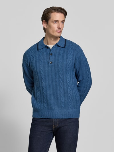 Männermodel trägt Regular Fit Strickpullover mit Woll-Anteil von Scotch & Soda in Blau, Polokragen, Ganzkörperansicht von vorne. Elastischer Material-Mix, elastische Abschlüsse, Rückenlänge bei Größe M 69 cm.