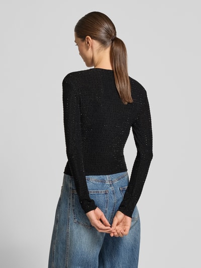 Frauenmodel trägt Slim Fit Langarmshirt mit Strasssteinen von Armani Exchange in Schwarz mit Strick-Optik, Rückansicht, Ganzkörperansicht.