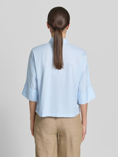 Frauenmodel trägt Boxy Fit Bluse mit 3/4-Arm von Emily Van den Bergh in Hellblau aus Reine Baumwolle mit Hemdblusenkragen und Knopfleiste, Rückenlänge 55 cm, Ärmellänge 36 cm, Ganzkörperansicht Rückansicht.