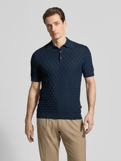 Męski model nosi Slim Fit Poloshirt aus reiner Baumwolle Modell 'Heritage' von Matinique w kolorze granatowym, faktura w kratkę, krój slim fit, polokrage, ściągacze, długość tyłu w rozmiarze M: 70 cm, całopostaciowy widok z przodu.