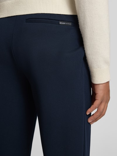 Männermodel trägt Tapered Chino mit Viskose-Anteil von Tom Tailor Denim, Optik: Unifarben, Label-Stitching-Applikation, Gesäßtaschen, Detailaufnahme